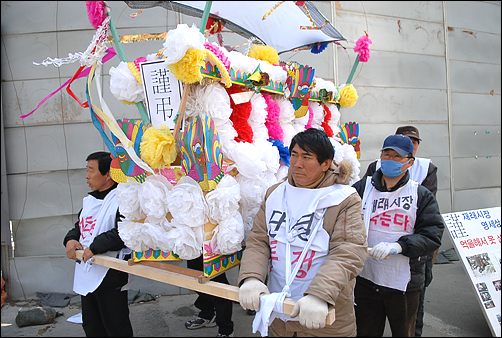 부산 감만동 삼성홈플러스 건설현장 앞에서 "죽어가는 재래시장을 살려달라"며 상여를 멘 영세상인들 